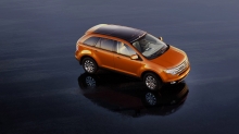 Оранжевый Ford Edge на зеркальном мокром асфальте